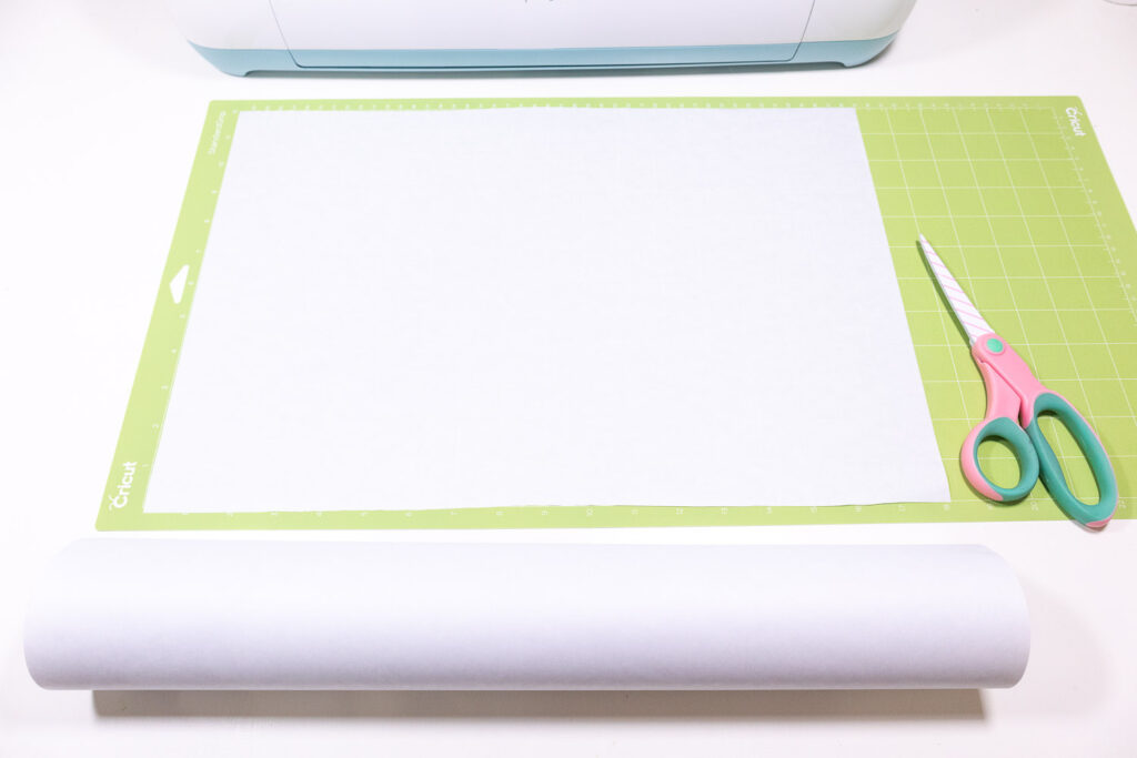 White freezer paper placed flat on green Cricut mat.