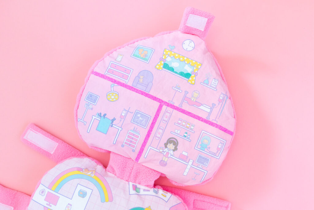 The top half of a Polly Pocket dog costume featuring an illustration of a pet hospital.